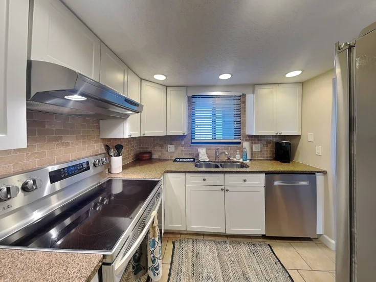 Renovated kitchen with stainless steel appliances and granite counters